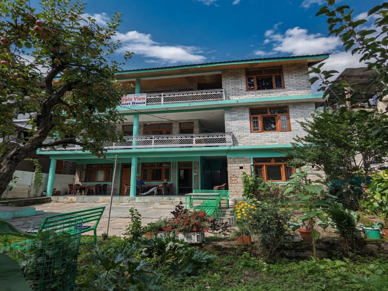 Apple View Guesthouse exterior with beautiful garden and apple trees in Old Manali